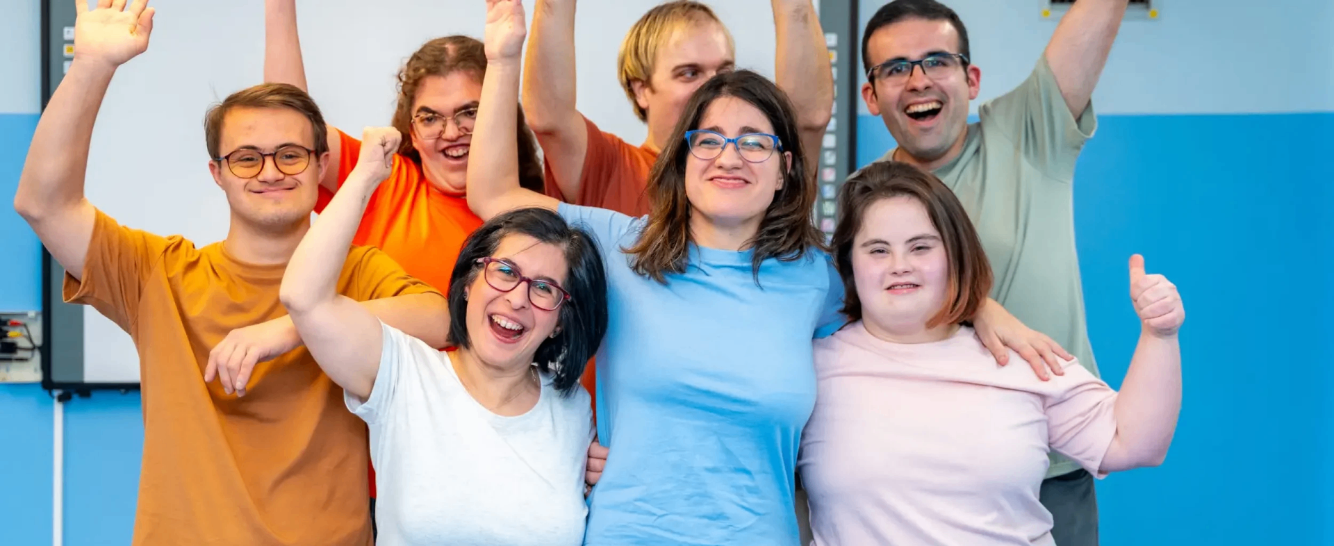 A joyful group of adults with intellectual and developmental disabilities cheering together.